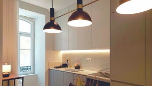 A modern kitchen with pendant lighting, a window, and a small dining area. - Flat 101 • Lisbon • 2 bedrooms • Elevator • AC (Lisbon)
