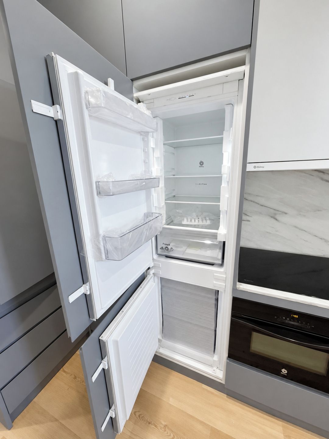 A modern kitchen with a built-in refrigerator, oven, and a microwave.