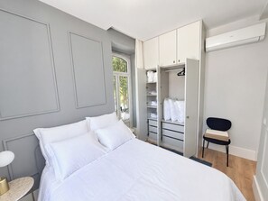Ein Schlafzimmer mit einem Bett, einem Kleiderschrank und einem Stuhl.