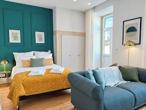 A hotel room with a bed, a sofa, a window, and artwork on the walls. - Studio 205 Lisbon • Balcony • Elevator • AC • WiFi (Lisbon)