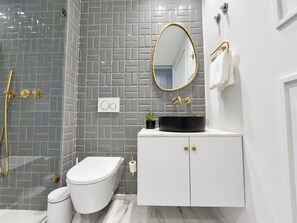 Modern bathroom vanity with a black basin, oval gold-framed mirror and geometric grey tiles - Studio 205 Lisbon • Balcony • Elevator • AC • WiFi (Lisbon)