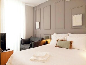 A hotel room with a large bed, a desk with a computer, and a TV. - Studio Lisbon • Balcony • Elevator • A/C • Parking (Lisbon)