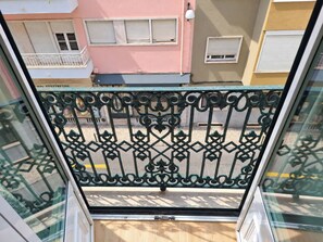 A balcony with a decorative metal railing, a view of adjacent buildings, and a clear sky. - Studio 302 Lisbon • Balcony • Elevator • AC • WiFi (Lisbon)