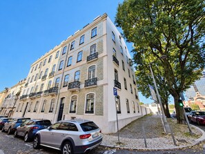 A multi-story building with a row of parked cars in front. - Apartment 502 • Lisbon • 1 bedroom • Elevator • AC (Lisbon)