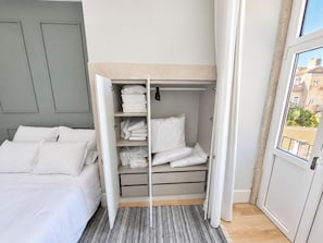 A bedroom with a bed, a wardrobe, and a view of buildings through a window. - Studio 305 Lisbon • Balcony • Elevator • AC • WiFi (Lisbon)
