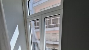 A corner room with a large window overlooking a multi-story building. - Studio 201 • Lisbon • Balcony • Elevator • AC (Lisbon)