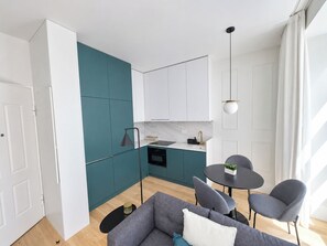 A modern kitchen with teal cabinets, a black countertop, and a single pendant light. - Studio 201 • Lisbon • Balcony • Elevator • WiFi (Lisbon)