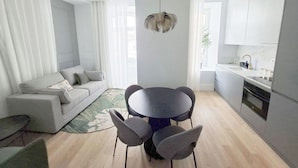 Un espace de vie moderne comprenant un coin repas, un canapé et une cuisine.