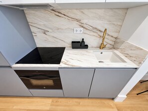 A compact kitchen with a built-in stove, a sink, and a dishwasher. - Apartment 105 • Lisbon • 1 bedroom • Elevator • AC (Lisbon)
