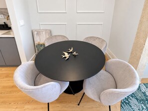 A round table with four chairs, a black tablecloth, and three bird-shaped decorations. - Apartment 105 • Lisbon • 1 bedroom • Elevator • AC (Lisbon)