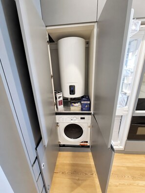 A compact laundry room with a washing machine, a dryer, and a water heater. - Apartment 105 • Lisbon • 1 bedroom • Elevator • AC (Lisbon)