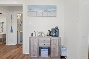 Eine Küchenzeile mit Kaffeemaschine, Wasserkocher und Aufbewahrungsbehältern.