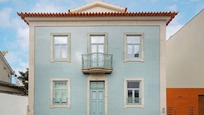 A building with a tiled facade, a central entrance door, and a balcony with a metal railing. - Matosinhos Coastal Breeze Studio (Matosinhos)