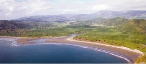 A coastal landscape with a river flowing into the sea, surrounded by green hills and a clear sky. - Casita de Vida 4.2, Guesthouse 1 Bdr, + 1 Bdr Casita option, Curu, Isla Tortuga (Paquera)