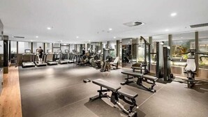 Un gimnasio moderno con cintas de correr, elípticas y bancos de pesas.