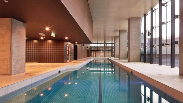 Piscina interior con paredes de azulejos y vista despejada del área de la piscina.