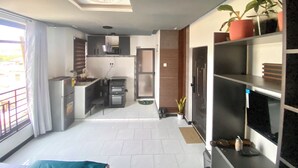 Een moderne keuken met een inbouwoven en een eethoek met een tafel en stoelen.