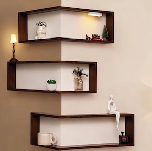 Un estante de esquina con tres repisas, cada una con varios objetos decorativos.