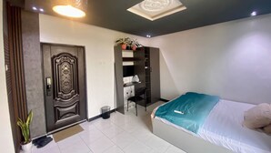 Een slaapkamer met een bed, een kledingkast, een deur en een plafondlamp.