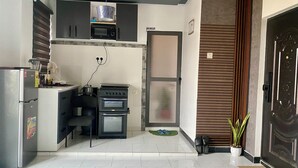 Een kleine keuken met een magnetron, oven en koelkast.