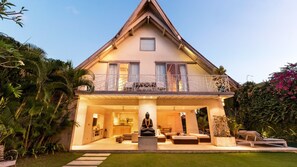 A modern house with a large balcony, a statue in the front, and a well-maintained garden. - Casa Mateo – Sumptuous Luxury 6-Bedroom Villa with Private Pool (badung)