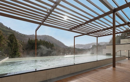 A hot spring area with a wooden deck and a view of a mountainous landscape.