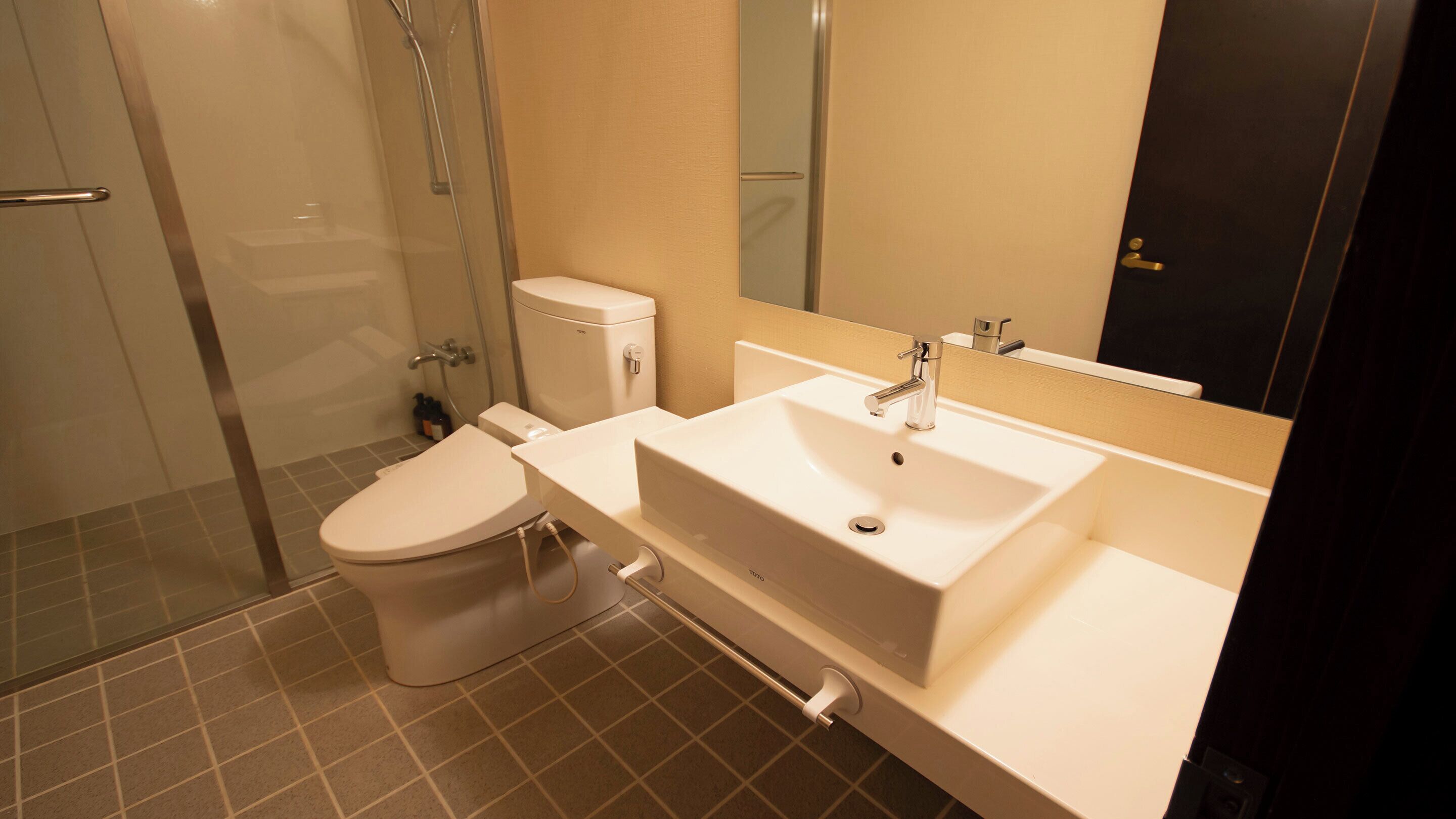 Un baño moderno con inodoro, lavabo y ducha.