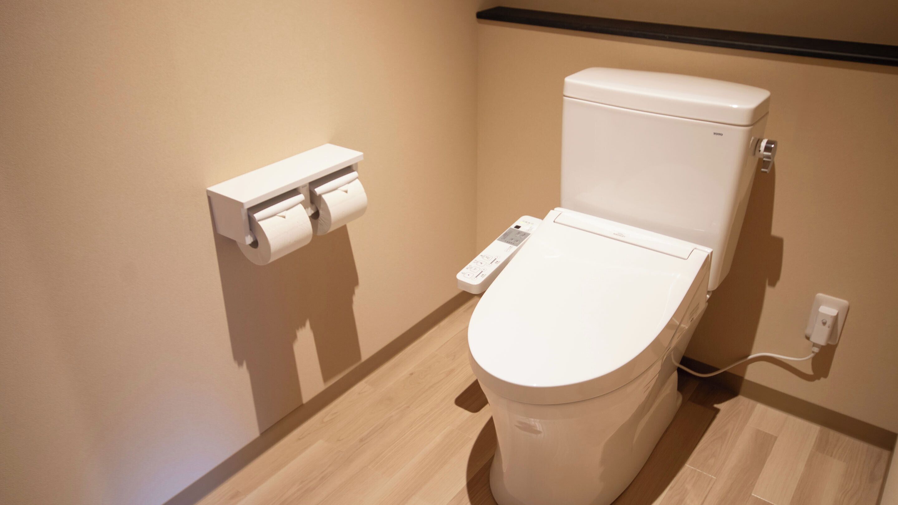 A modern toilet with a control panel and a toilet paper holder.