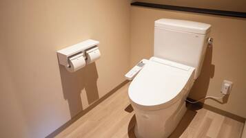 A modern toilet with a control panel and a toilet paper holder.