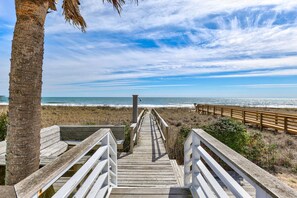 A wooden boardwalk leading to a beach with a palm tree on the left and a wooden fence on the right. - Boracay - The Ultimate 8,000 Sq. Ft. Oceanfront Estate (Kure Beach)