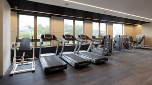 Un gimnasio con cintas de correr, elípticas y equipo de pesas.