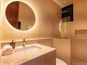 A modern bathroom with a marble sink, a large mirror, and a glass-enclosed shower. - Peregrina Tulum 110 1BR Lux with Jacuzzi (Tulum)