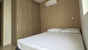 Ein Schlafzimmer mit einem Bett, einem Kleiderschrank und einer Klimaanlage.