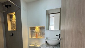 Ein modernes Badezimmer mit Toilette, Waschbecken und Dusche.