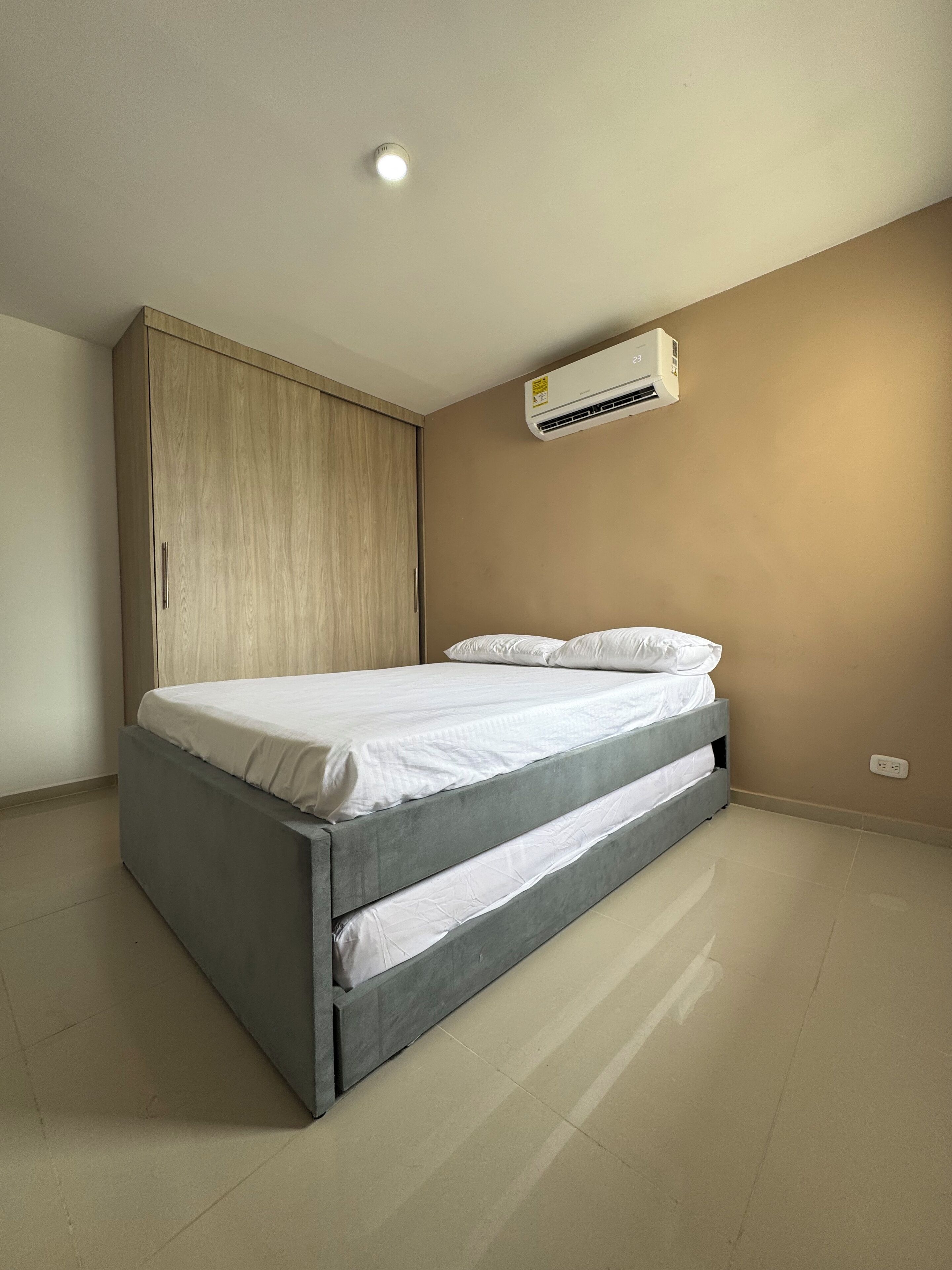 Ein Schlafzimmer mit einem Bett, einem Kleiderschrank und einer Klimaanlage.