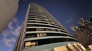 A tall, modern building with a curved facade and multiple windows.