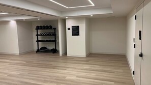 Ein Zimmer mit Holzboden, einer schwarzen Schuhablage und einem an der Wand befestigten Schild.