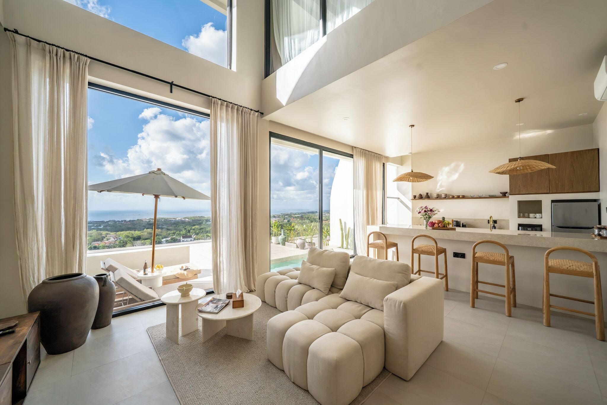 A modern living room with a sofa, a coffee table, and a view of the outdoors.