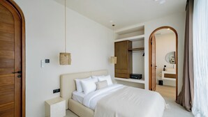 A bedroom with a bed, bedside table, and a hanging light fixture. - Villa Vista al Mar (Uluwatu)