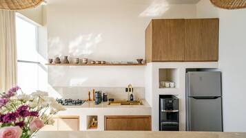 Una cocina moderna con gabinetes de madera, un refrigerador de acero inoxidable y un dispensador de agua empotrado.