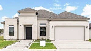 A modern two-story house with a garage, a front porch, and a well-maintained lawn. - 3-bedroom house (Alton)