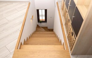 Una escalera de madera con vistas a una ventana y una planta.