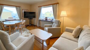 A cozy living room with a television, a dining table, and a sofa. - 3 bedroom beautiful home in Borgholm (Borgholm)