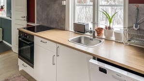 A modern kitchen with white cabinets, a stainless steel sink, a toaster, and a window with a view of trees. - 1 bedroom lovely home in Söderköping (Söderköping)