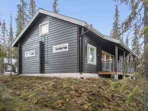 A two-story house with a dark exterior, a front porch, and a small deck. - Tuppuvaara by Interhome (Äkäslompolo)