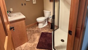 Een badkamer met toilet, wastafel en douche.