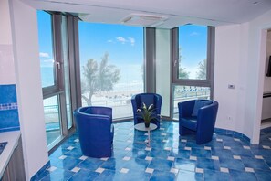 A balcony with a view of the sea, two blue chairs, and a small table with a plant. - Villa Fortunata - Small Apartment Right, Terracina, Italy (Terracina)