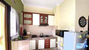 A compact kitchen with a microwave, kettle, and a refrigerator. - Home Sweet Home Dekat UMY by Simply Homy (Sleman)