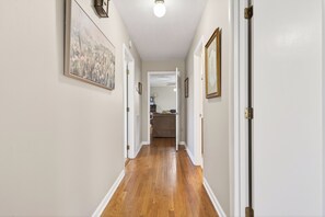A hallway with wooden flooring, white walls, and framed artwork. - NEW listing 4 minutes from CHL-Sligo Book for Memorial Day (Smithville)