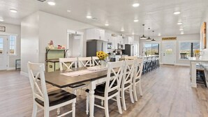 Uma cozinha espaçosa com armários brancos, uma ilha central e vista para o exterior.